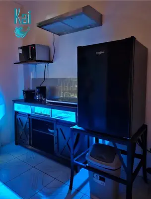 a kitchen with a counter with blue lights at Cabinas Kai in Quepos