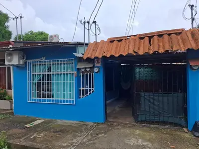 a blue house with a dog in a gate at Cabinas Kai in Quepos