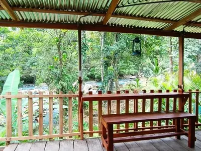 a wooden porch with a bench on a deck at Cabins river blue in Rio Celeste