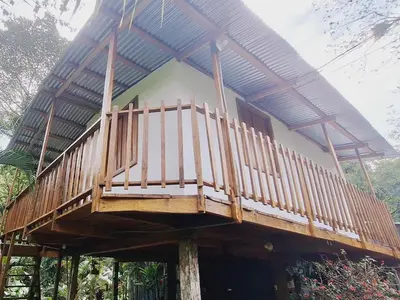 a house with a balcony on top of it at Cabins river blue in Rio Celeste