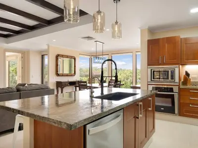 a kitchen with a large counter top and a living room at Stunning Spacious Luxury Condo 5-Star Reserva Conchal - Carao in Playa Conchal