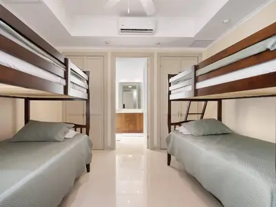 two beds in a room with two bunk beds at Stunning Spacious Luxury Condo 5-Star Reserva Conchal - Carao in Playa Conchal