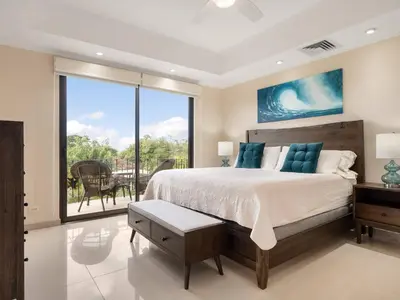 a bedroom with a large bed and a balcony at Stunning Spacious Luxury Condo 5-Star Reserva Conchal - Carao in Playa Conchal