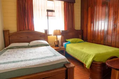 a bedroom with two beds and a window at Casa Hotel Sura in San José