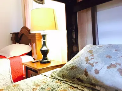 a bedroom with a bed and a lamp on a night stand at Casa Hotel Sura in San José