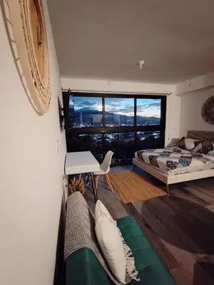 a bedroom with a bed and a desk and a window at Valle de Escalante in San José