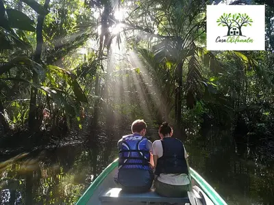 two people sitting on a boat in the water at Chilamate Jungle View in Tortuguero