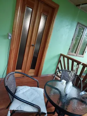 a glass table and chairs in a room with a door at Chilamate Jungle View in Tortuguero