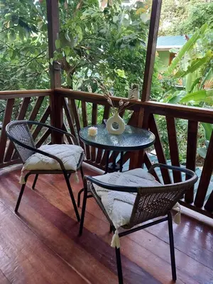 a table and two chairs on a wooden deck at Chilamate Jungle View in Tortuguero