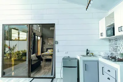 a kitchen with white walls and a sliding glass door at Arenal View Villas in Fortuna