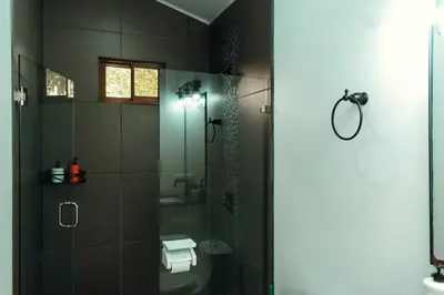 a bathroom with a shower and a toilet and a sink at Arenal View Villas in Fortuna