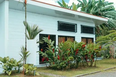 a white house with plants in front of it at Arenal View Villas in Fortuna
