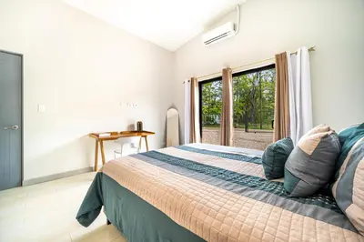a bedroom with a large bed and a window at Casa Montana Azul @ Catalina Cove in Brasilito