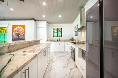 a kitchen with white cabinets and marble counter tops at Casa Montana Azul @ Catalina Cove in Brasilito