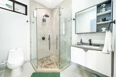 a bathroom with a glass shower with a toilet and a sink at Casa Montana Azul @ Catalina Cove in Brasilito