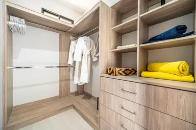 a walk in closet with wooden cabinets and a sliding door at Casa Montana Azul @ Catalina Cove in Brasilito