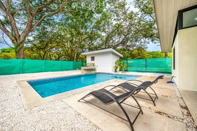 a swimming pool with two chairs next to a house at Casa Montana Azul @ Catalina Cove in Brasilito