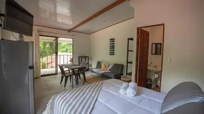 a bedroom with a large white bed and a table at Stella's Santa Teresa in Mal País