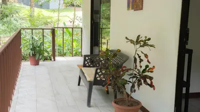 a porch with a bench and potted plants at Stella's Santa Teresa in Mal País