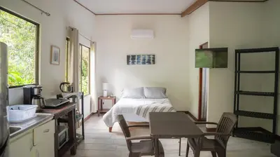 a bedroom with a bed and a table and chairs at Stella's Santa Teresa in Mal País