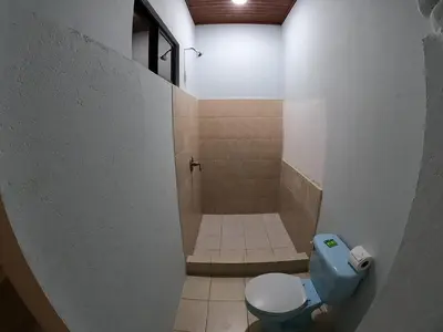 a bathroom with a blue toilet and a shower at Laureles Collection Uvita - Cabinas Los Laureles in Uvita