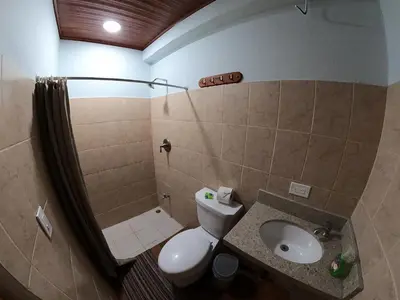 a bathroom with a toilet and a sink at Laureles Collection Uvita - Cabinas Los Laureles in Uvita
