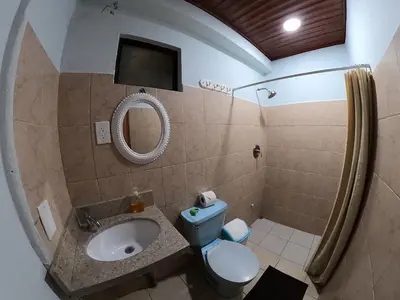 a bathroom with a toilet and a sink and a mirror at Laureles Collection Uvita - Cabinas Los Laureles in Uvita