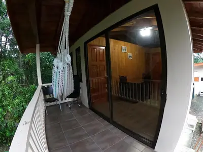 a balcony with a large glass door on a house at Laureles Collection Uvita - Cabinas Los Laureles in Uvita