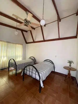 a room with two beds and a ceiling fan at La Dehesa B&B en San Joaquín de Flores in Heredia