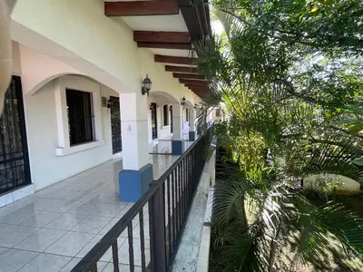 a balcony of a house with a fence and trees at La Dehesa B&B en San Joaquín de Flores in Heredia