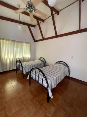 two beds in a room with a ceiling fan at La Dehesa B&B en San Joaquín de Flores in Heredia