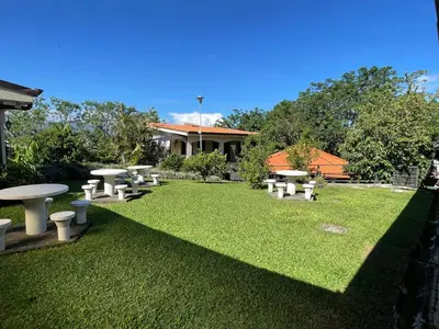 a group of picnic tables on a lawn at La Dehesa B&B en San Joaquín de Flores in Heredia