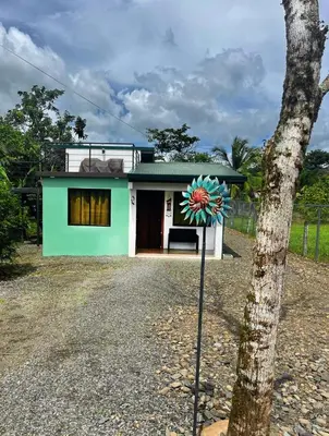 a house with a flower on a pole in front of it at Casa La Vega in Florencia