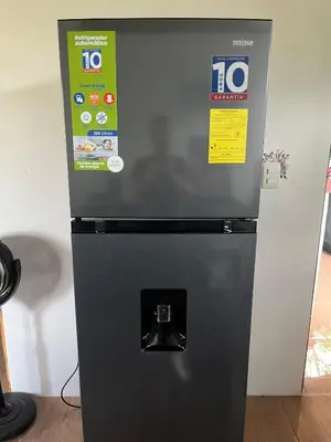 a black refrigerator with two signs on it at Casa La Vega in Florencia
