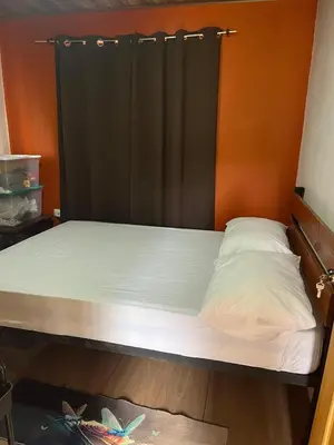 a bed with a black headboard in a room at Casa La Vega in Florencia