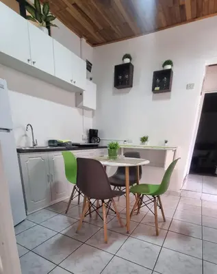a kitchen with a table and green chairs at Apartamento Adriana in Cartago
