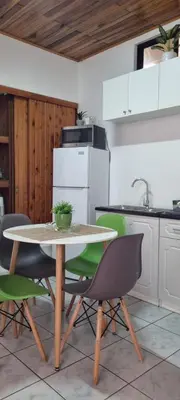 a kitchen with a table and green chairs at Apartamento Adriana in Cartago