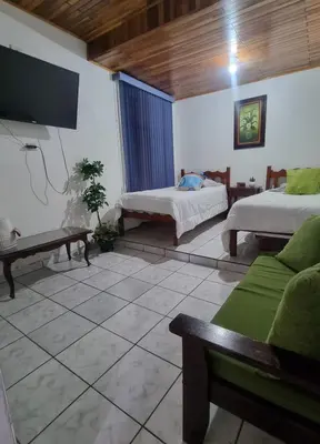a living room with two beds and a tv at Apartamento Adriana in Cartago