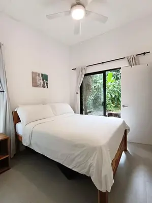 a bedroom with a large white bed and a window at Santa Teresa Manzanillo Walk to Beach, New Home, Center of Tranquil Town in Boca de Ario