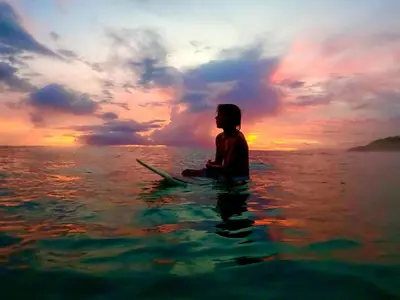 a person sitting on a surfboard in the ocean at Santa Teresa Manzanillo Walk to Beach, New Home, Center of Tranquil Town in Boca de Ario