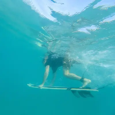 a person on a surfboard in the water at Santa Teresa Manzanillo Walk to Beach, New Home, Center of Tranquil Town in Boca de Ario