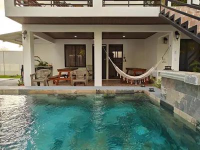 a swimming pool in front of a house at AJ Suites - Modern Beach Apartments with Pool and Full Kitchen in Uvita