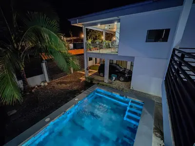 a swimming pool in front of a house at night at AJ Suites - Modern Beach Apartments with Pool and Full Kitchen in Uvita