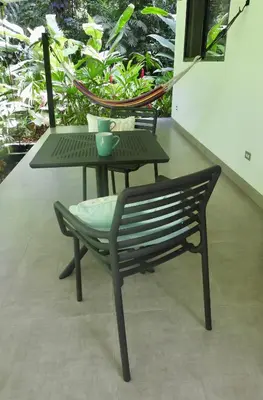 a table and a chair sitting next to a table at Colibri Jungle Casita in Dominical