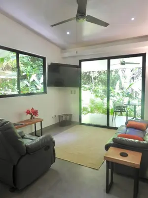 a living room with a couch and a ceiling fan at Colibri Jungle Casita in Dominical