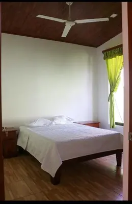 a bedroom with a bed with a ceiling fan at Casa Jicaro in Nosara