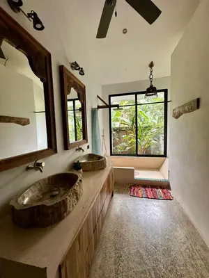 a bathroom with two sinks and a large window at Casa de Bosque con Piscina in Naranjito
