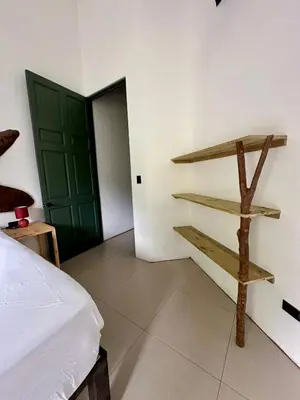 a room with a bed and a green door at Casa de Bosque con Piscina in Naranjito