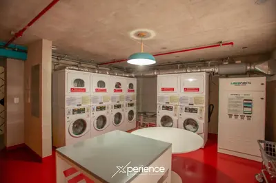 a laundry room with four washer and dryer machines at Lux at 15, Pool, Gym and Stylish City Stay in Hatillo