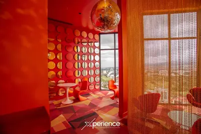 a room with a red wall with a table and a window at Lux at 15, Pool, Gym and Stylish City Stay in Hatillo